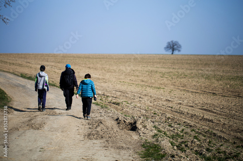 Obraz na płótnie a family wandering through dry fields, through the countryside, family travels w salonie