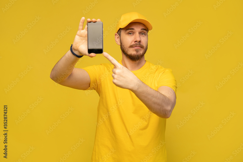 Portrait of a excited happy young delivery man in yellow cap standing isolated over white background Portrait of a excited happy young delivery man in yellow cap standing isolated over white background