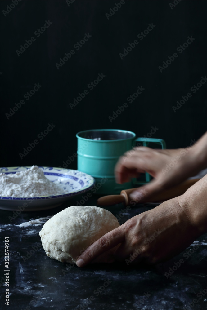 Fototapeta premium Dough ,making dough with flour on a black background, bread and pizza dough