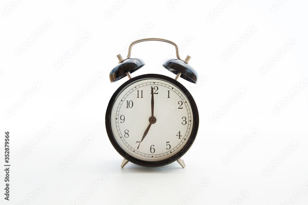 Black retro alarm clock isolated on white background. Copy space. Blank template backdrop. Early morning seven o'clock. Time to wake up. Selective focus Black retro alarm clock isolated on white background. Copy space. Blank template backdrop. Early morning seven o'clock. Time to wake up. Selective focus