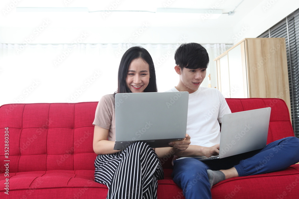 couple using laptop sitting in room work from home. Technology and communication couple using laptop sitting in room work from home. Technology and communication