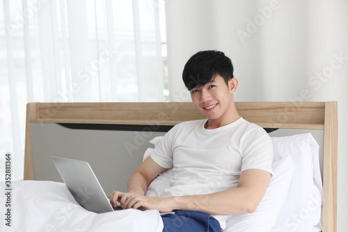 man using  laptop on bedroom    work from home. Technology and communication