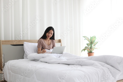 woman using laptop on bedroom , work from home. Technology and communication