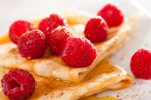 delicious  pancakes with fresh raspberries and honey