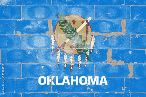 Foto The national flag of the United States of Oklahoma against a sky blue color, in the center there is a shield made of buffalo leather, traditional for the Osage tribe, with seven eagle feathers