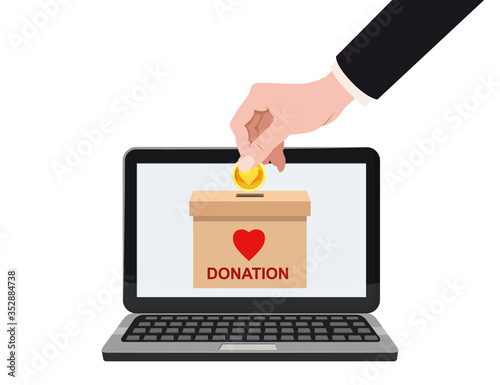 Donate online payments. Hand insert money gold coin in to the donation box on a laptop PC display