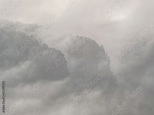 Spectacular aerial view of hilly silhouettes and misty valleys. Misty awaking of beautiful fairy valley.