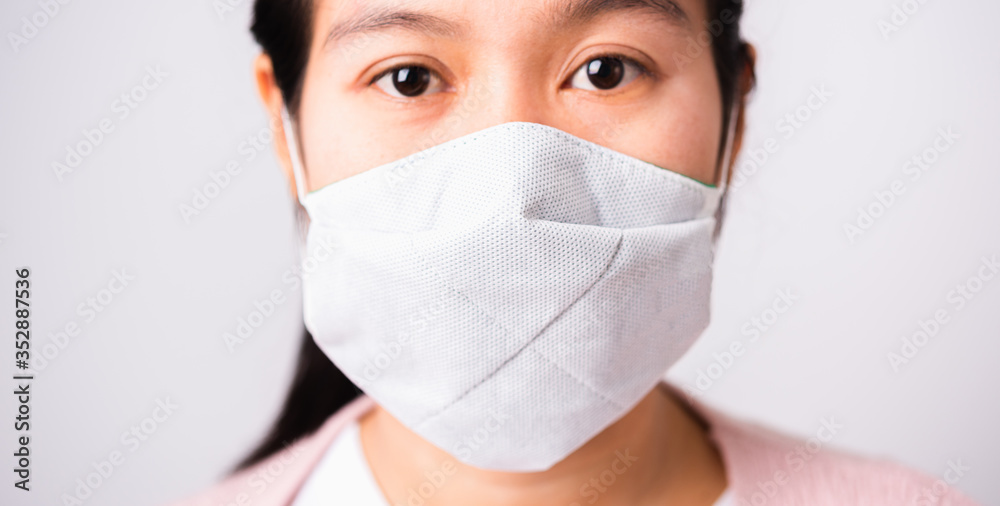 Asian beautiful woman wearing protection face mask against coronavirus her looking to camera, studio shot isolated on white background with copy space, COVID-19 or corona virus concept Asian beautiful woman wearing protection face mask against coronavirus her looking to camera, studio shot isolated on white background with copy space, COVID-19 or corona virus concept
