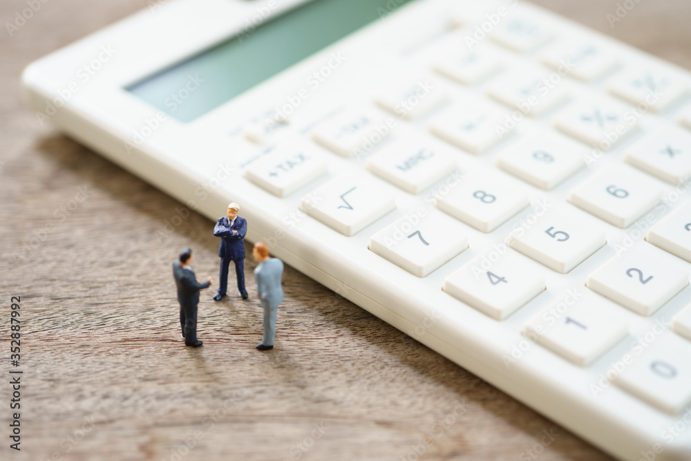 Miniature people Pay queue Annual income (TAX) for the year on calculator. using as background business concept and finance concept with copy space for your text or design. Miniature people Pay queue Annual income (TAX) for the year on calculator. using as background business concept and finance concept with copy space for your text or design.