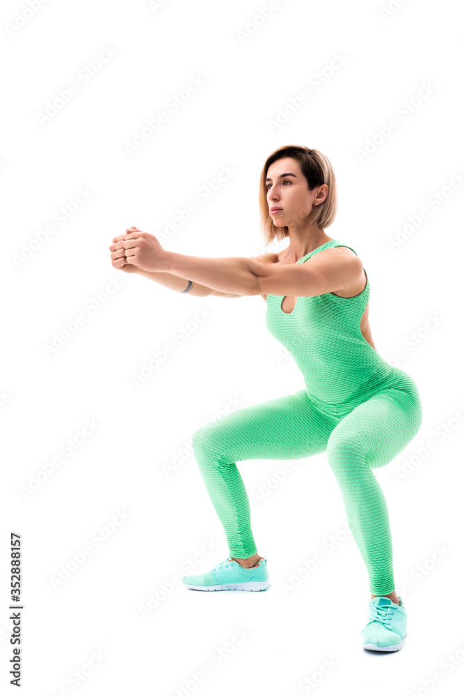 Studio shot of an athletic woman doing squats isolated over white background. Studio shot of an athletic woman doing squats isolated over white background.