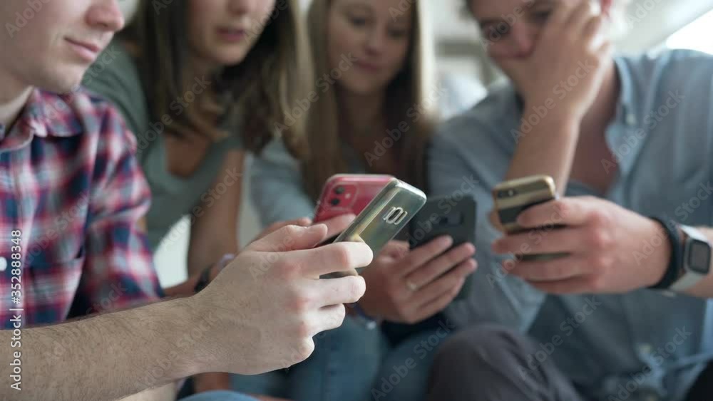 group of four young people with their phone group of four young people with their phone