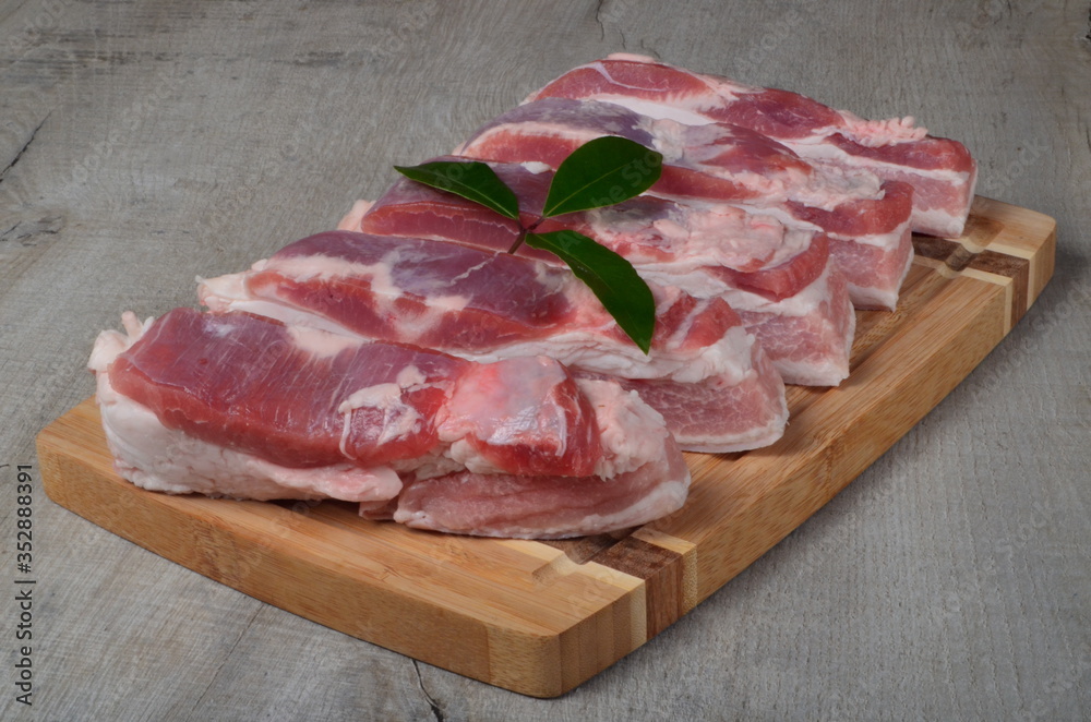 raw pork belly slice on a wooden board. Sliced pork on a cutting board