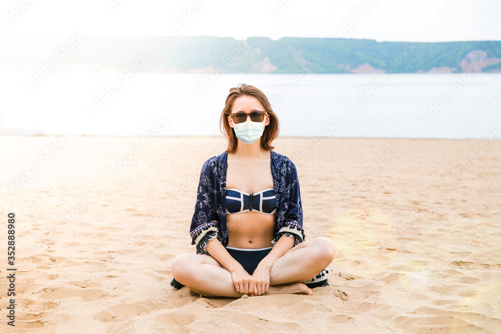 Beautiful European girl on an empty beach in a bikini and a light summer Cape Beautiful European girl on an empty beach in a bikini and a light summer Cape