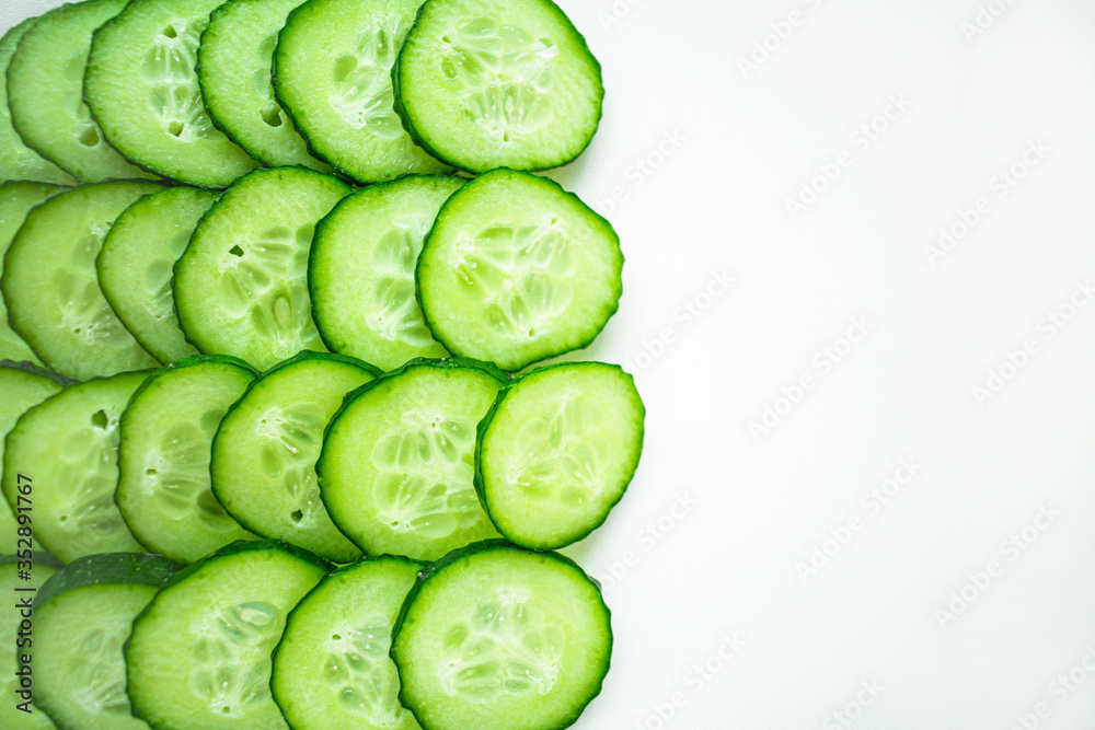 Cucumber slices are arranged in a row on a white background Cucumber slices are arranged in a row on a white background