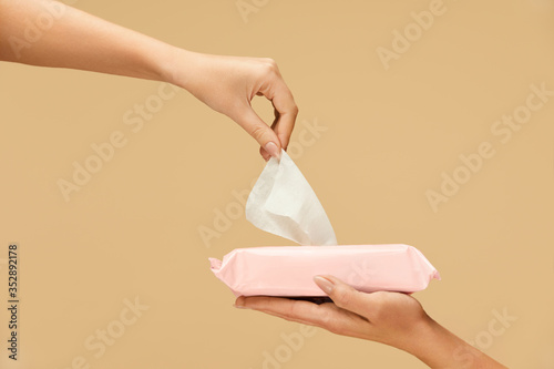 Hand Hygiene. Female Picked Wet Wipes From Pink Pack On Beige Background. Home And Travel Hygiene For Virus And Bacterial Infection Prevention.