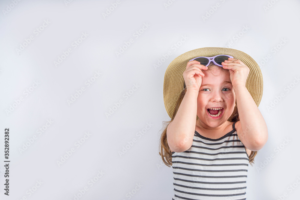 Summer vacation and holiday concept. Cute little smiling girl in a summer hat with sunglasses. Background for vacation banner, mockup Summer vacation and holiday concept. Cute little smiling girl in a summer hat with sunglasses. Background for vacation banner, mockup