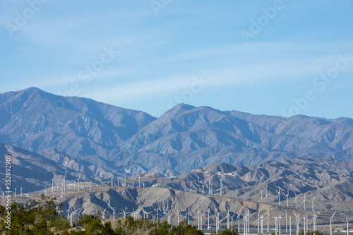 Landscape of wind turbines at the base of desert mountains, with space for text © Peter