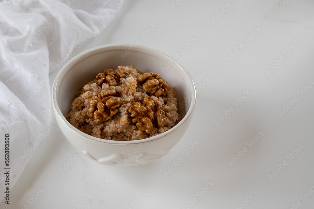 Spelled porridge with walnut. Proper nutrition concept. White background. Spelled porridge with walnut. Proper nutrition concept. White background.