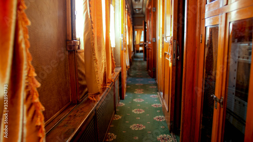 Photo Interior of old wooden train wagon with wooden walls and carpets on floor