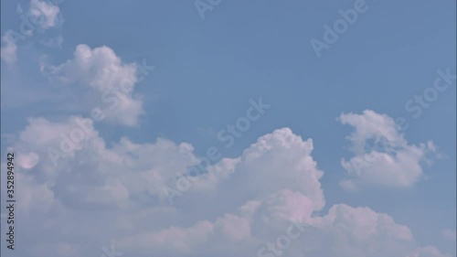 Time lapse white clouds in blue sky.