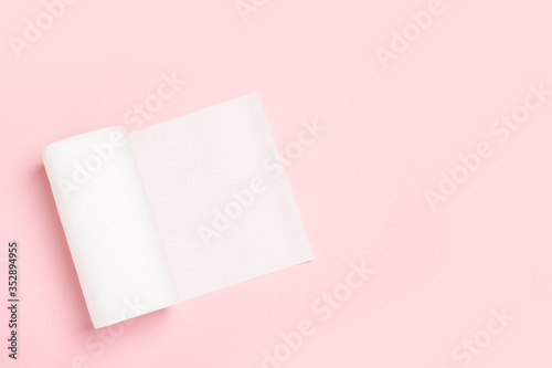 Roll of paper towels on a pink background. Concept is 100% natural product, delicate and soft. Flat lay, top view. Banner