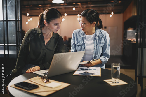 Two businesswomen going over work together in an office