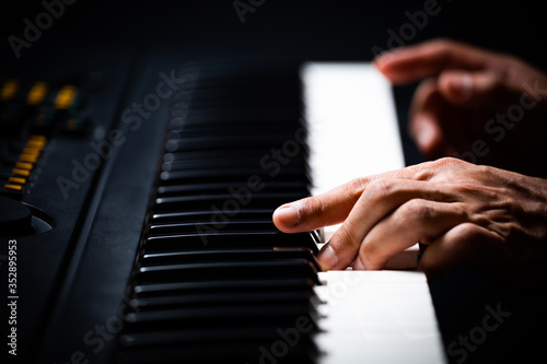 Fototapeta professional male pianist hands playing on piano keys