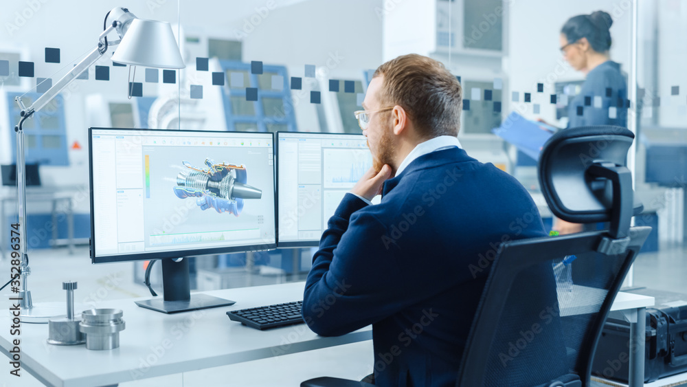 Industrial Engineer Working on a Personal Computer, Two Monitor Screens Show CAD Software with 3D Prototype of Hybrid Electric Engine and Charts. Working Modern Factory.