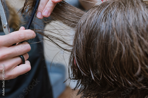 Women's haircut at home. Hairdresser cuts a girl at home.