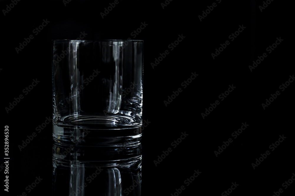 one glass for whiskey on a black background one glass for whiskey on a black background
