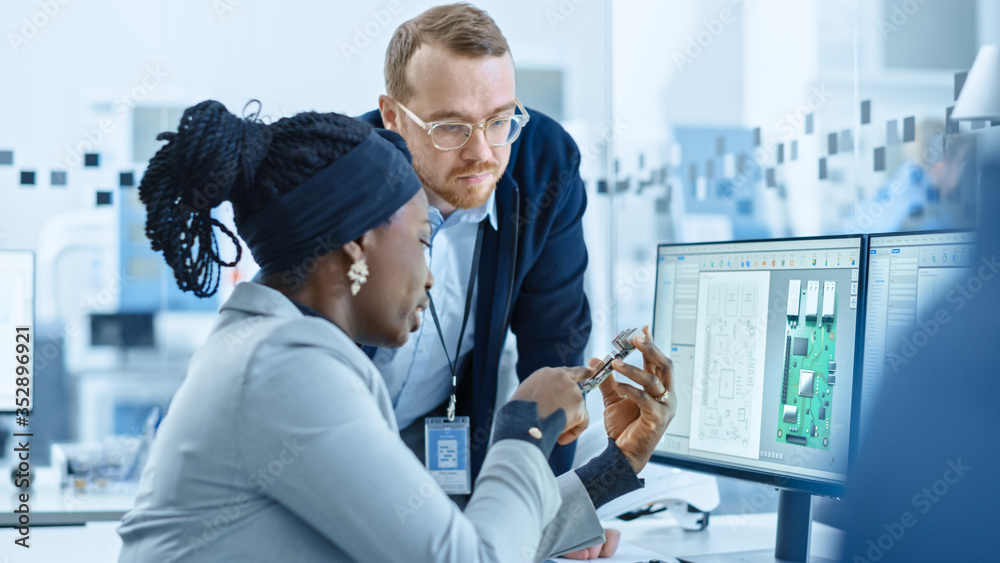 Modern Electronics Factory: Female Supervisor Talks to a Male Electrical Engineer who Works on Computer with CAD Software. Designing PCB, Microchips, Semiconductors and Telecommunications Equipment - obrazy, fototapety, plakaty 
