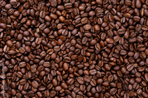 Freshly roasted coffee beans overhead shot background © Yury