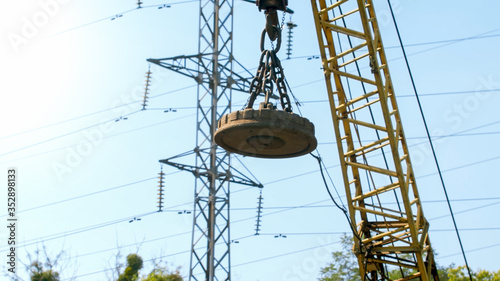 Fotografie Image of big electric magnet hanging on crane on the dump