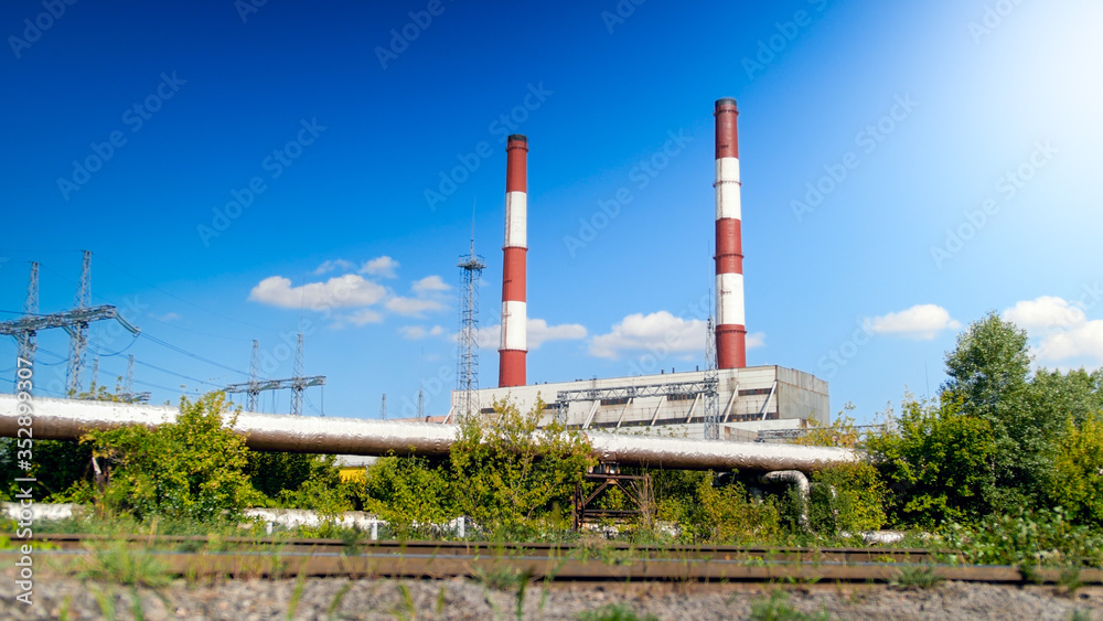 Image of two red and white chimney on electric powerhouse against clear blue sky Image of two red and white chimney on electric powerhouse against clear blue sky