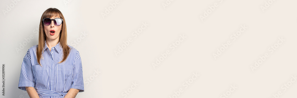 surprised young girl on a light background. Concept is win, sale, discount, gift. Banner surprised young girl on a light background. Concept is win, sale, discount, gift. Banner