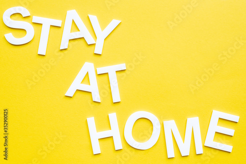 Top view of lettering stay at home on yellow surface