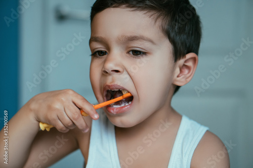 Картината върху платно adorable, diligent kid brushing teeth in bathroom