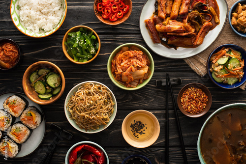 Billede på lærred top view of korean traditional dishes near chopsticks and cotton napkin on woode