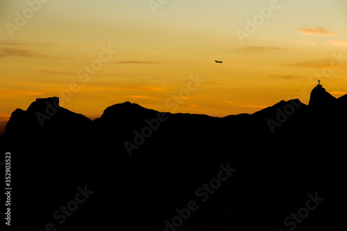 airplane flying over the mountains of Rio de Janeiro, Pedra da Gávea and Pedra Bonita, corcovado hill in a beautiful sunset.