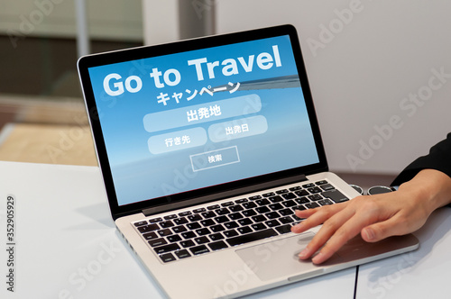 航空券のオンライン予約検索のイメージ ノートパソコンでフライト予約検索の画面を見せている女性の手 go toトラベル