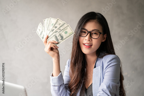 Premium Photo  Dollar in a businesswoman hand. an asian woman is working  from home or office and glad to get dollar money from work and from a  supplementary career or part-time