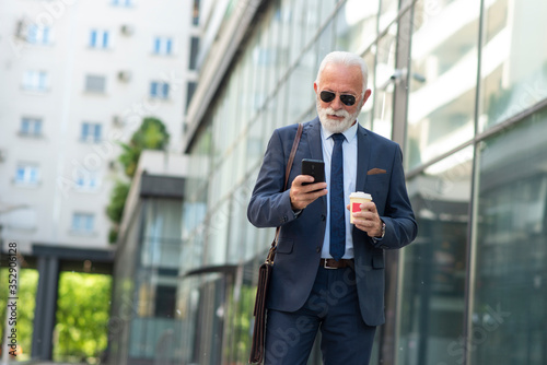 Business senior man using phone outdoor