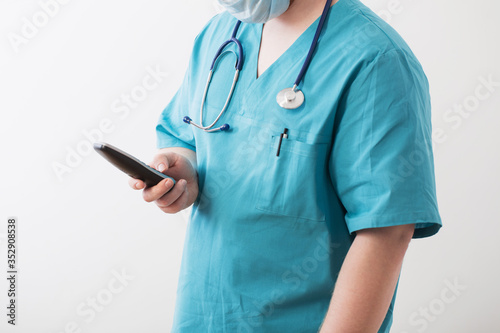 doctor in medical mask with phone on white background