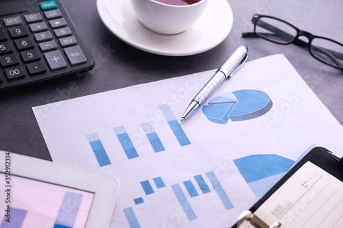 financial charts and office supplies on desk 