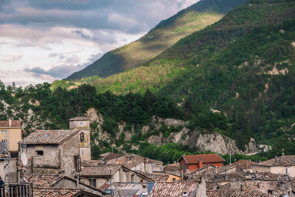 A picturesque view of a medieval French village in the low Alps mountain valley in the early evening (Puget-Theniers, Alpes-Maritimes, France)