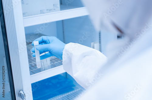 Close up scientist hand opening storage reagent container.Scientist hand holding reagent tube during prepare specimen for auto machine analysis.Laboratory medical analysis concept.