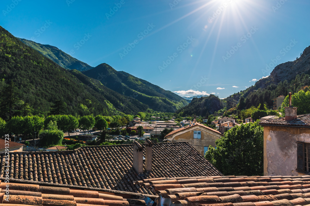 A picturesque wide landscape view of the Alps mountains valley and a French medieval village on a sunny day (Puget-Theniers, Alpes-Maritimes, France) A picturesque wide landscape view of the Alps mountains valley and a French medieval village on a sunny day (Puget-Theniers, Alpes-Maritimes, France)
