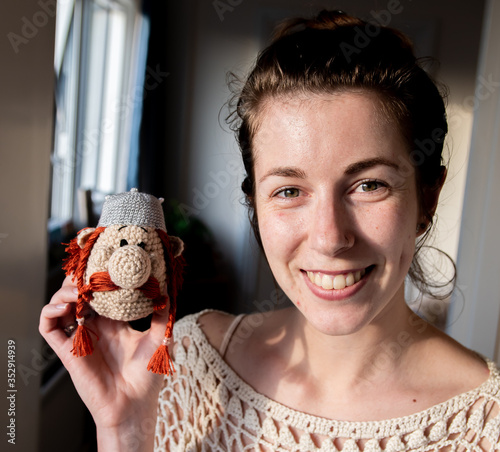 A beautiful young woman crochet artist and creator poses with her artwork - the head of the character Obelix from Asterix and Obelix photo