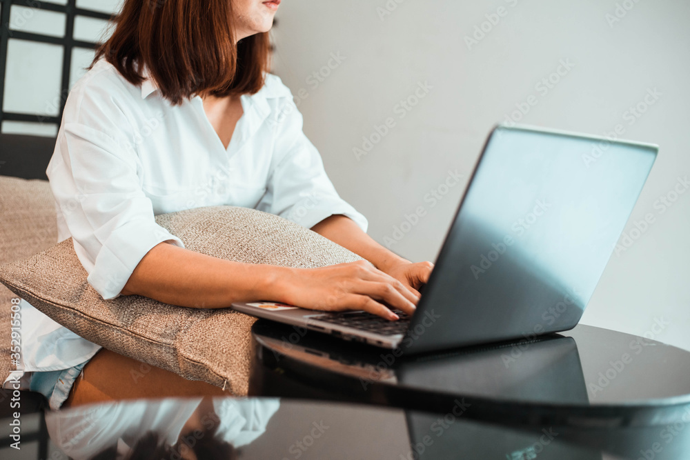 young woman working on laptop computer while sitting at the living room. work from home concept young woman working on laptop computer while sitting at the living room. work from home concept