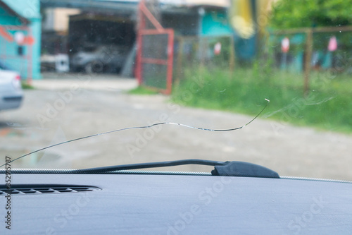 .close-up photo of a cracked windscreen, view from inside of the car